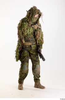 Andrew Elliott in Ghillie Pose with Gun holding gun standing…